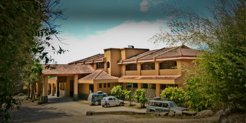 The terracotta-roofed main building of Hotel Montaña Monteverde among trees