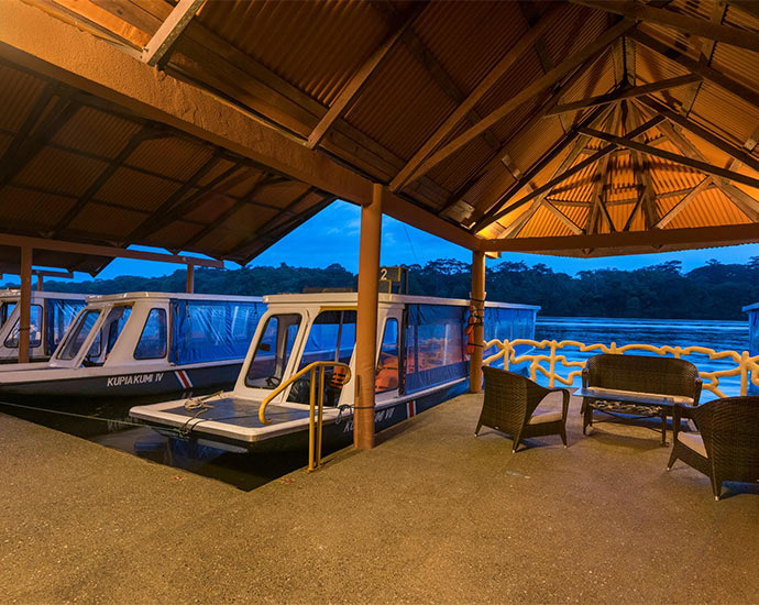 Covered boat dock at Laguna Lodge on the Tortuguero lagoon at dusk
