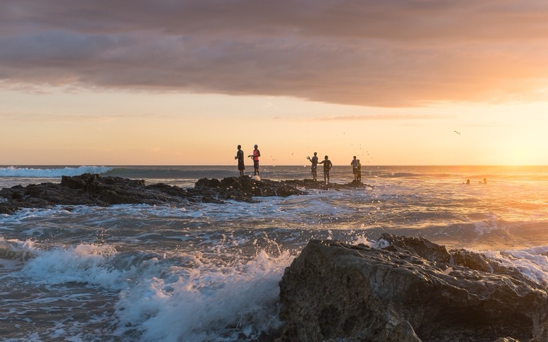 Fishermen on the rocks at sunset on Playa Santa Teresa